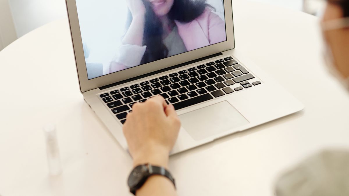 自宅でノートパソコンを使いオンラインで相談している人物